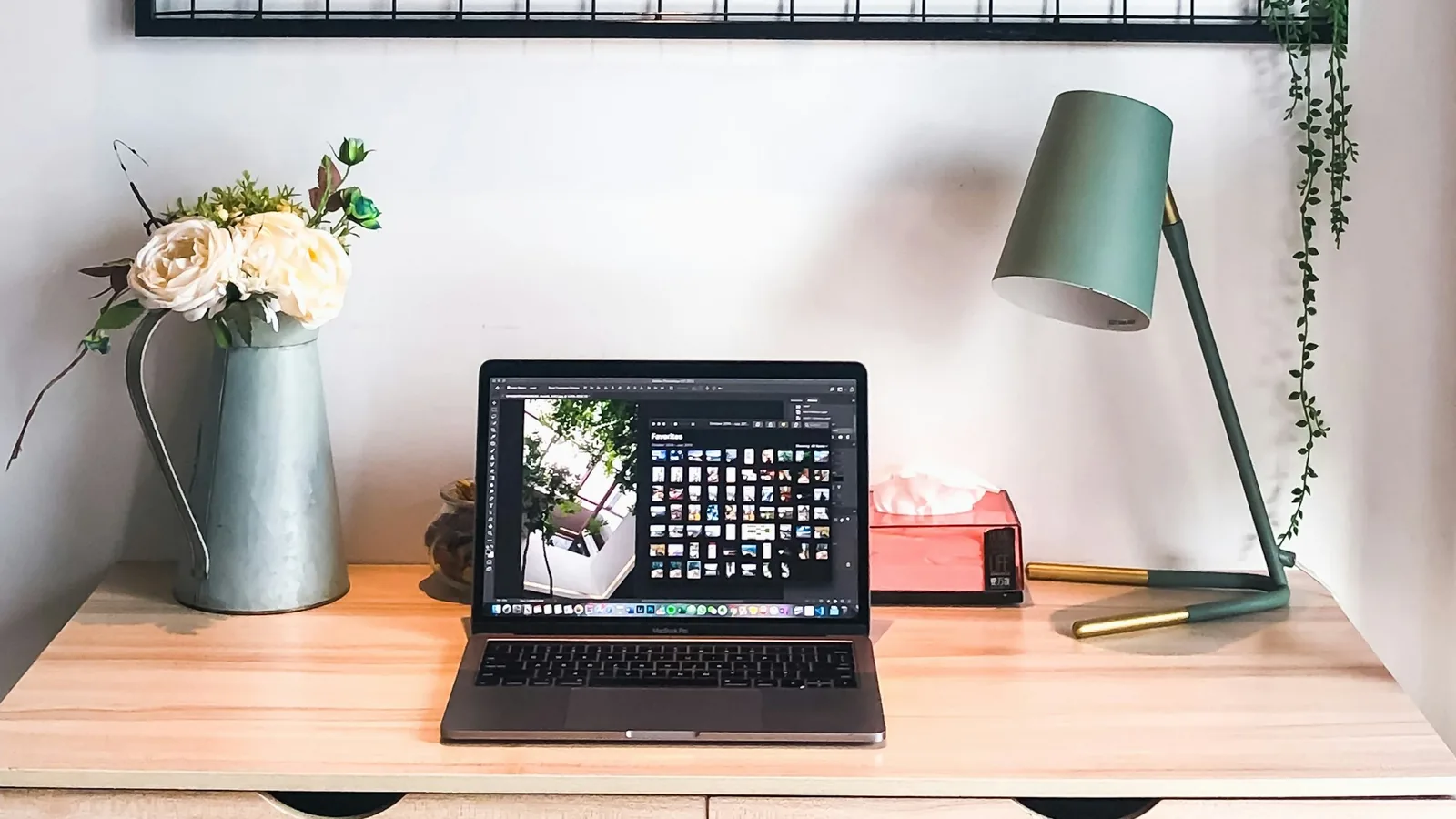 Bureau de travail chaleureux avec ordinateur portable, fleurs et lampe